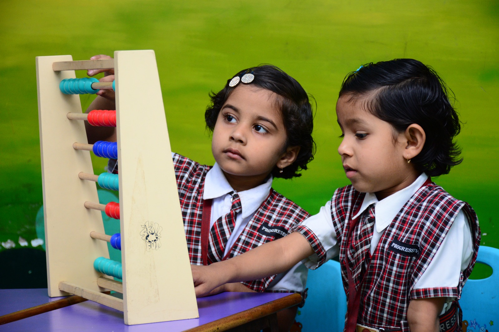 A young child holding a drawing in a classroom